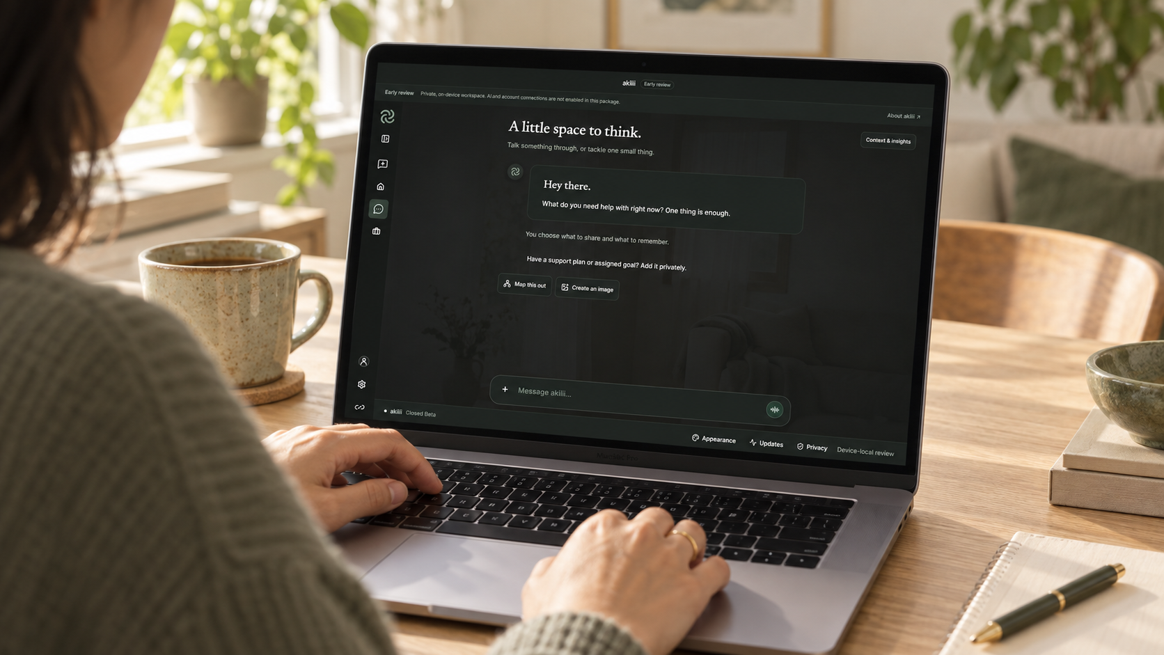Illustrative scene of an adult using the akilii Chat interface on a MacBook at a home desk
