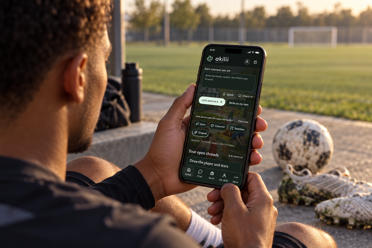 Illustrative adult footballer using the akilii mobile interface beside a training pitch